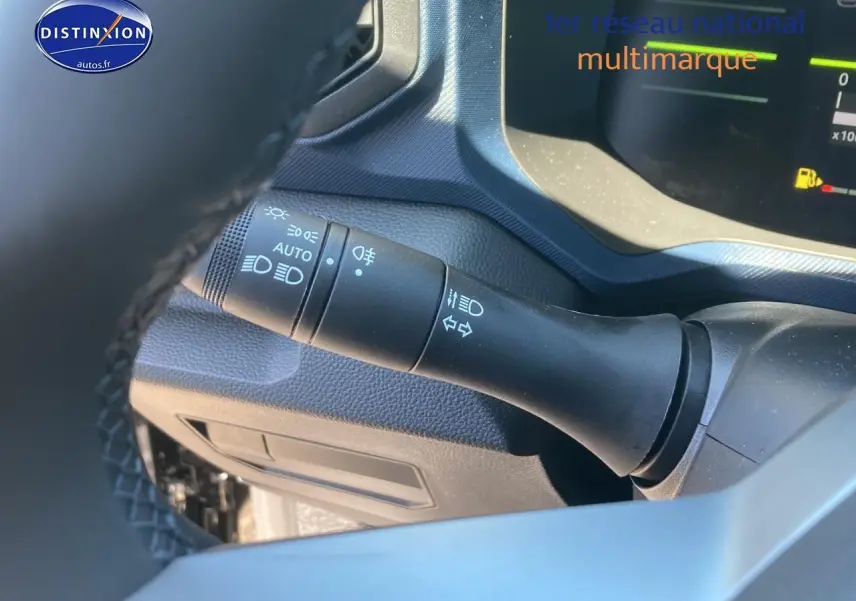 Gros plan sur la manette de commande des phares et clignotants du tableau de bord du Dacia Duster noir 2025.
