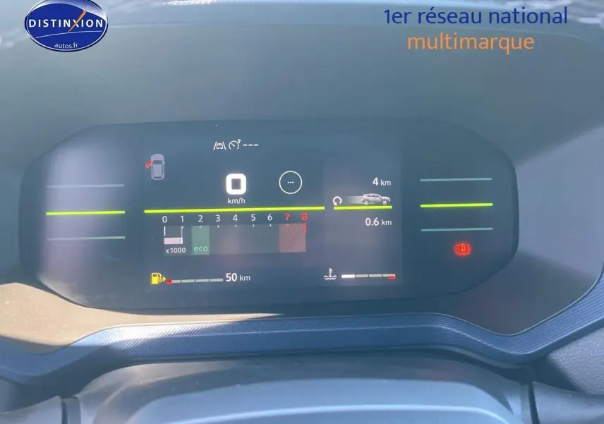 Tableau de bord numérique du Dacia Duster 2025 affichant vitesse, compte-tours et autonomie, vue de face rapprochée.