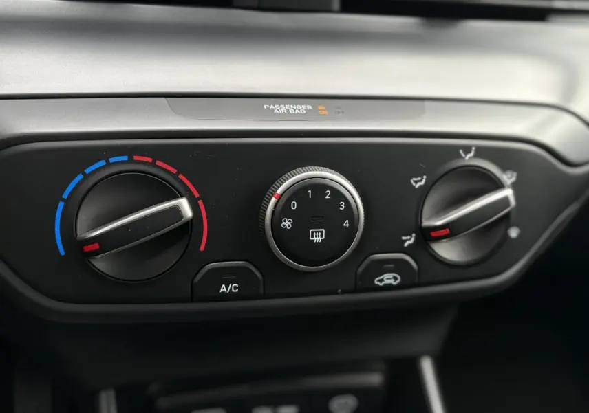 Gros plan sur les commandes de climatisation manuelle de la Hyundai i20 2025 en gris Aurora Metal.
