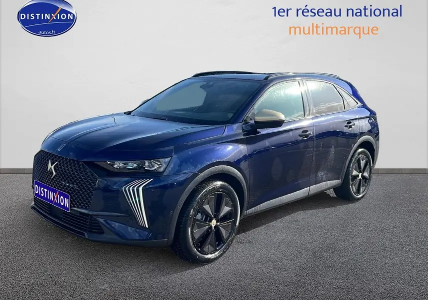 DS7 bleu 3/4 avant droit avec calandre distinctive et jantes noires brillantes sur fond neutre.