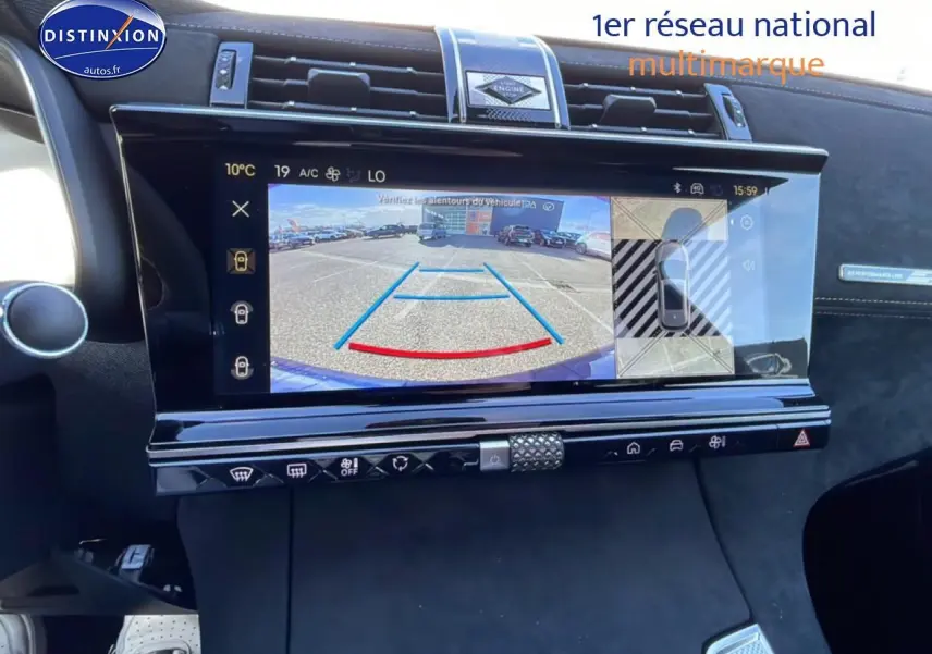 Vue intérieure centrée sur l'écran tactile affichant la caméra de recul du DS7 bleu, avec détails du tableau de bord noir.