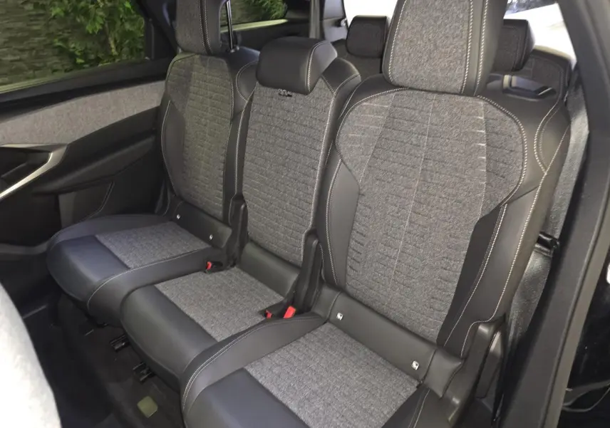 Vue latérale droite sur la banquette arrière tissu gris et cuir noir du Peugeot 5008 noir 2025.