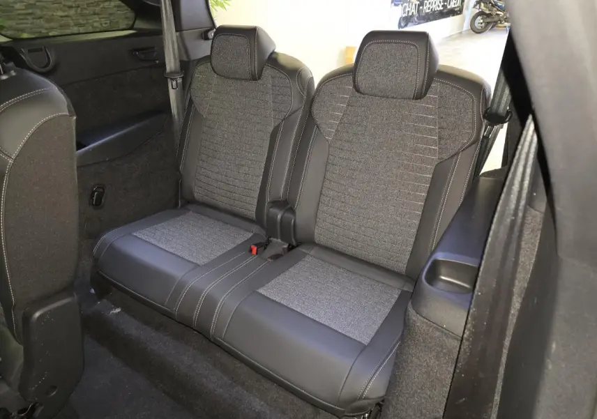 Vue rapprochée de la banquette arrière 2 places en tissu gris et cuir noir du Peugeot 5008 hybride 2025.