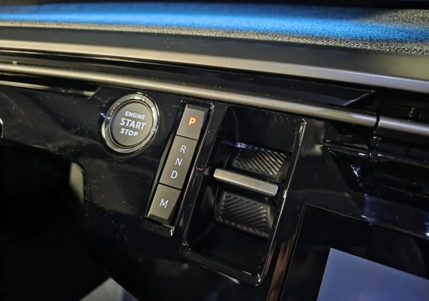 Détail de la console centrale noire brillante du Peugeot 5008 2025 avec bouton start/stop et commandes de boîte auto.