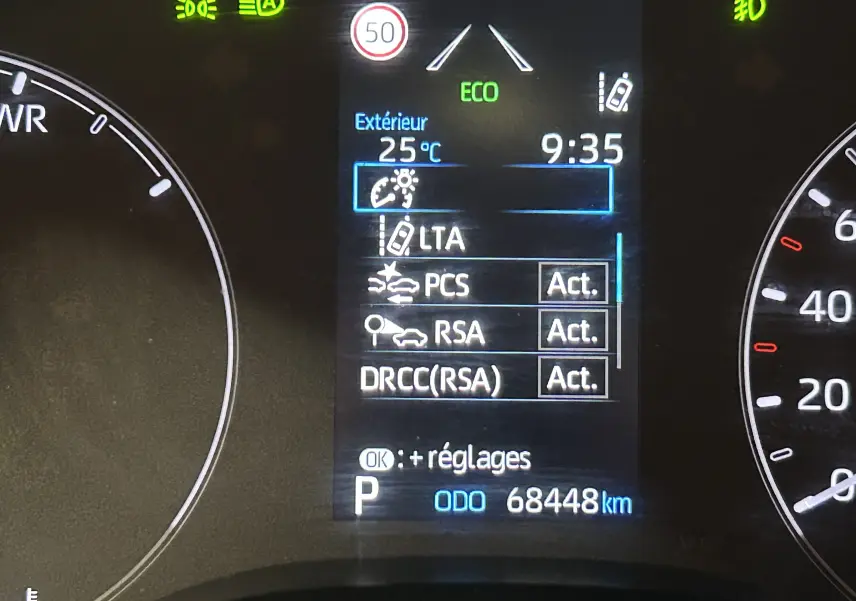 Tableau de bord de Toyota Yaris hybride 2021 montrant l'écran central avec affichage des aides à la conduite et compteur kilométrique.