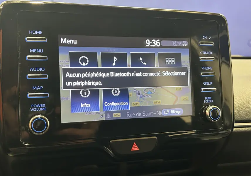 Écran tactile central de la Toyota Yaris 116h blanc, affichant le menu principal avec message Bluetooth non connecté.
