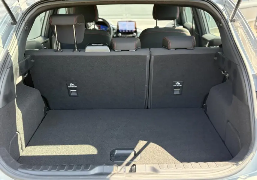Coffre ouvert du Ford Puma gris Solar, vue arrière montrant la banquette arrière et l'espace de chargement vide.