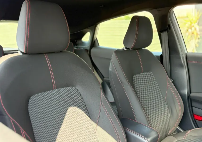 Gros plan sur les sièges avant en tissu noir avec surpiqûres rouges du Ford Puma Gris Solar 2020 finition ST Line.