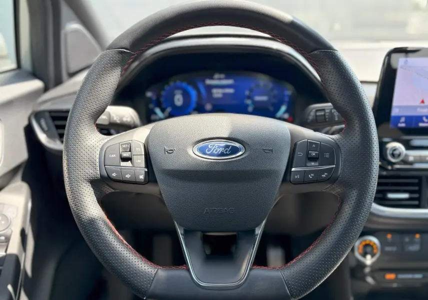 Volant en cuir noir à surpiqûres rouges de la Ford Puma ST Line 2020 avec tableau de bord numérique et écran GPS tactile.