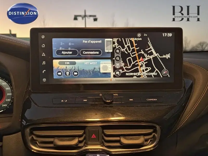 Vue rapprochée de l'écran central tactile du tableau de bord du Nissan Juke 1.6 Hybrid Tekna 2025 en gris perle métallisé.