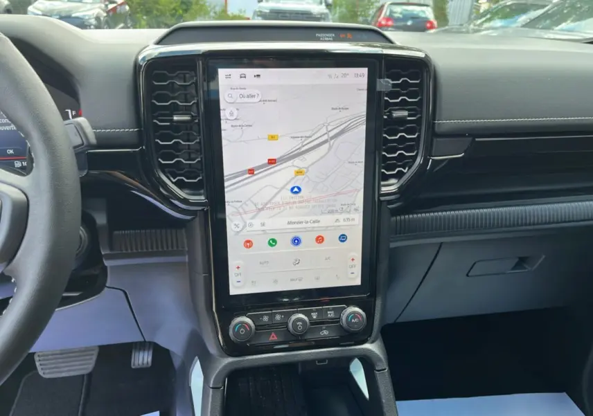 Vue intérieure centrée sur la console centrale tactile verticale du Ford Ranger gris zen avec volant cuir multifonctions partiel visible.