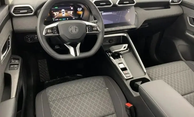 Vue intérieure du tableau de bord et volant du MG ZS 2025, avec sièges tissu noir et écran tactile 10,25 pouces.