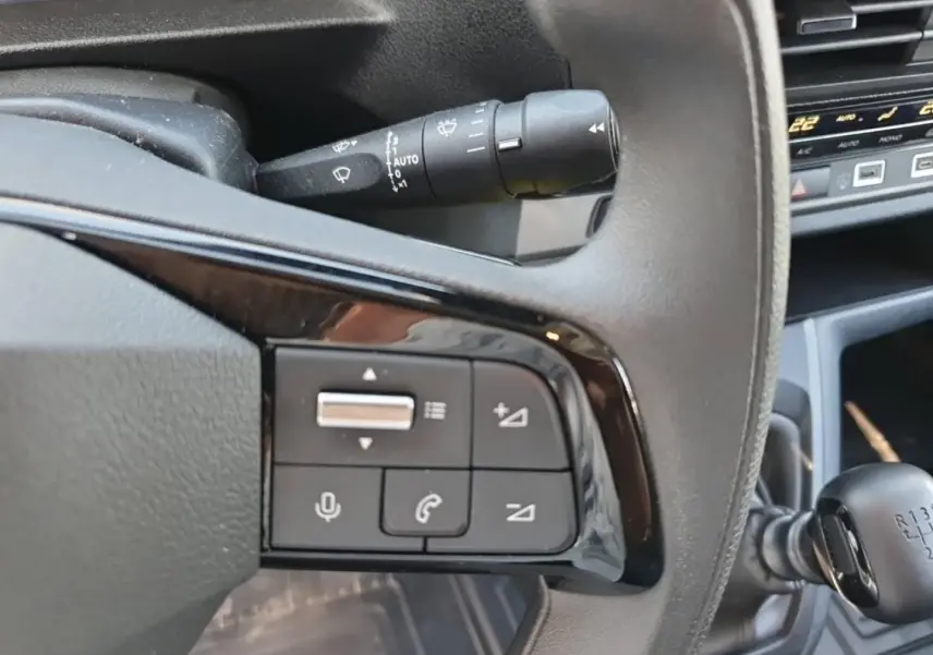 Gros plan sur les commandes audio au volant noir et levier de vitesse manuel dans l’habitacle du Toyota Proace Fourgon blanc Glacier.