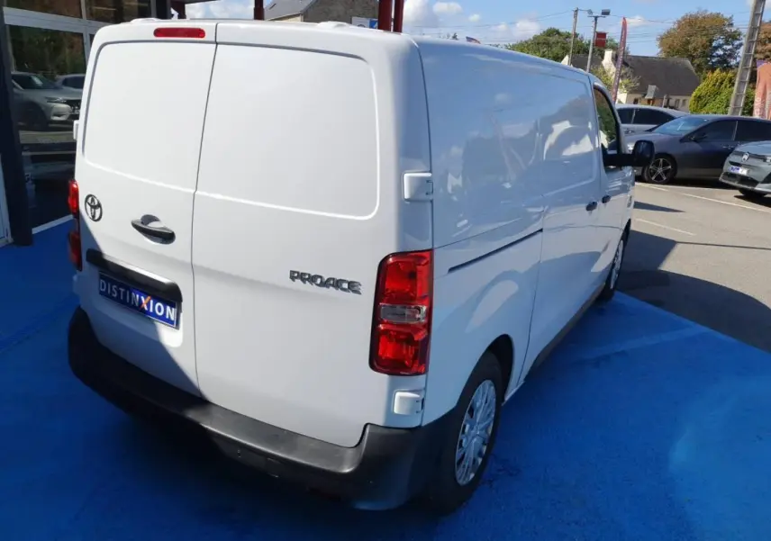 Toyota Proace Fourgon blanc glacier vu en 3/4 arrière droit sur un parking extérieur.