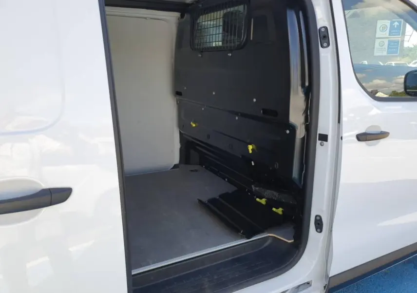 Vue latérale droite du Toyota Proace Fourgon blanc Glacier avec porte coulissante ouverte sur l’espace de chargement vide.