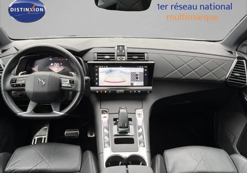 Intérieur du DS7 2024 en cuir noir, vue frontale sur tableau de bord avec écran tactile et volant multifonction.