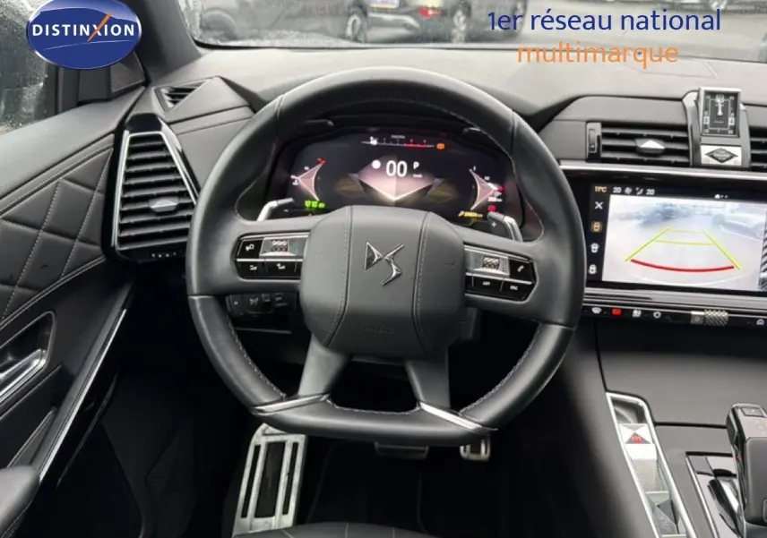 Vue intérieure centrée sur le volant cuir noir du DS7 2024 avec tableau de bord numérique et écran de recul.