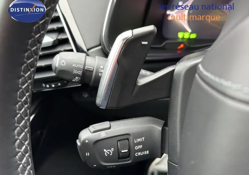 Gros plan sur les commandes au volant du DS7 2024 gris titane, montrant le régulateur de vitesse et les commandes d'éclairage.