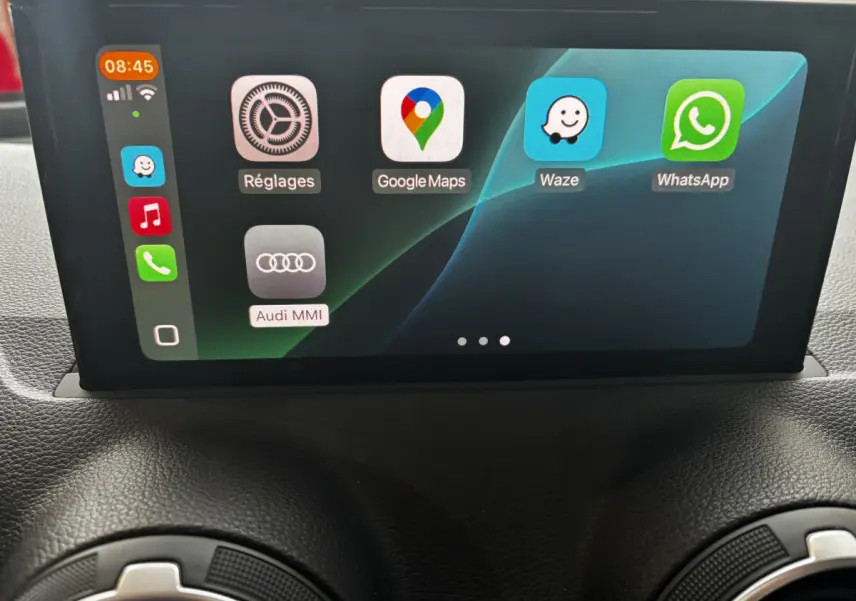 Écran central tactile de l'Audi Q2 35 TFSI S Line 2023 affichant les applications Google Maps, Waze et WhatsApp.