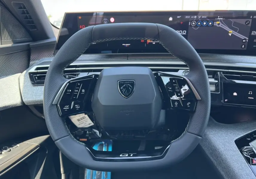 Volant cuir Peugeot 3008 Hybrid GT Alcantara vu de face avec tableau de bord numérique et finitions grises modernes