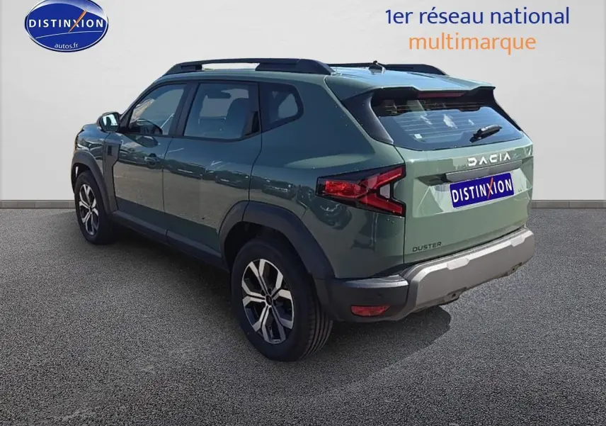 Vue 3/4 arrière droite d'un Dacia Duster 2025 vert kaki avec jantes alu et barres de toit visibles.