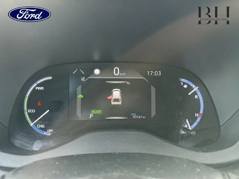 Tableau de bord numérique de Toyota Yaris Cross blanc, affichant la vitesse à 0 km/h et porte avant gauche ouverte.