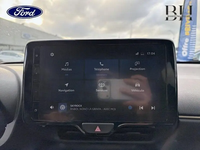 Vue avant de la Toyota Yaris Cross 116h Trail AWD-i 2023 en blanc lunaire nacré, avec jantes alu visibles.