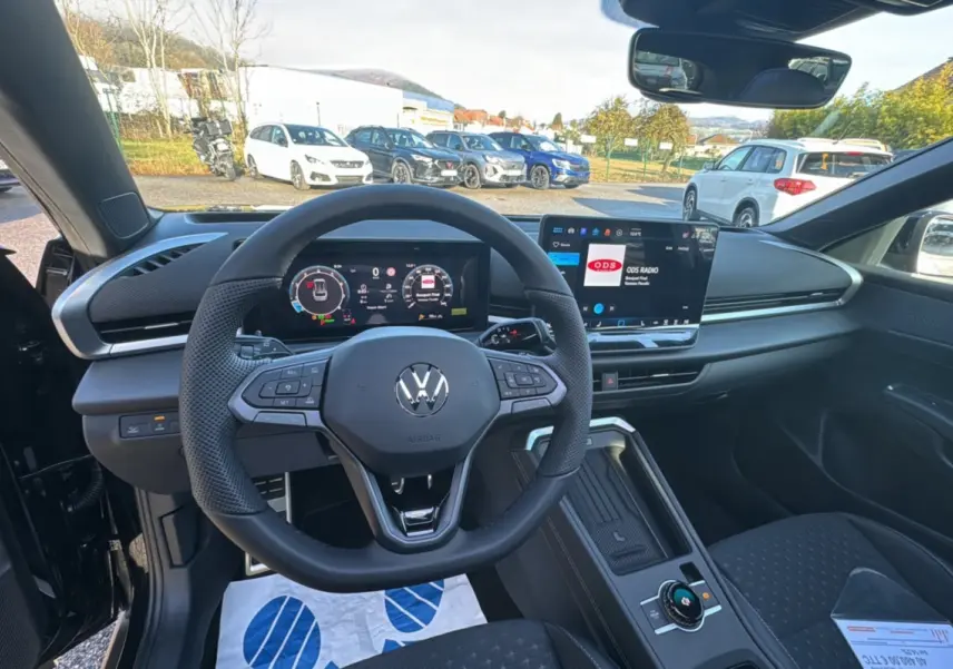 Vue intérieure centrée sur le volant cuir multifonctions du Volkswagen T-Roc noir ebène avec tableau de bord digital.