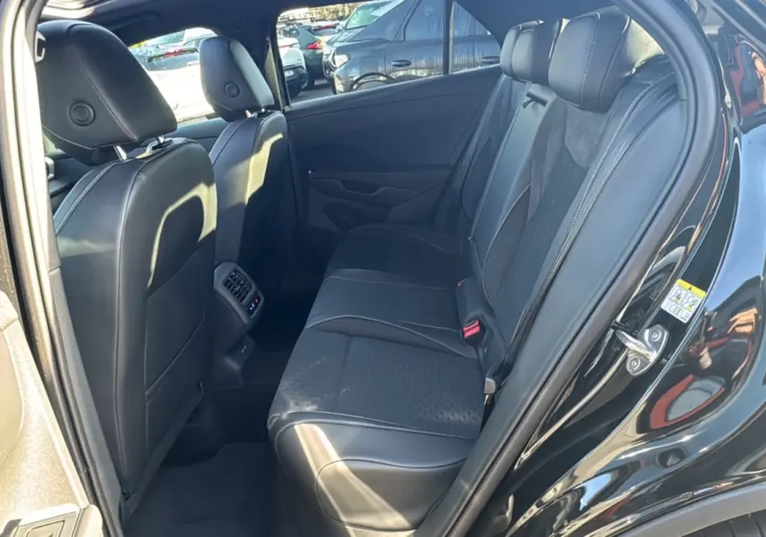 Vue intérieure arrière droite du Volkswagen T-Roc noir ébène, montrant la banquette en tissu et cuir avec appuie-têtes.