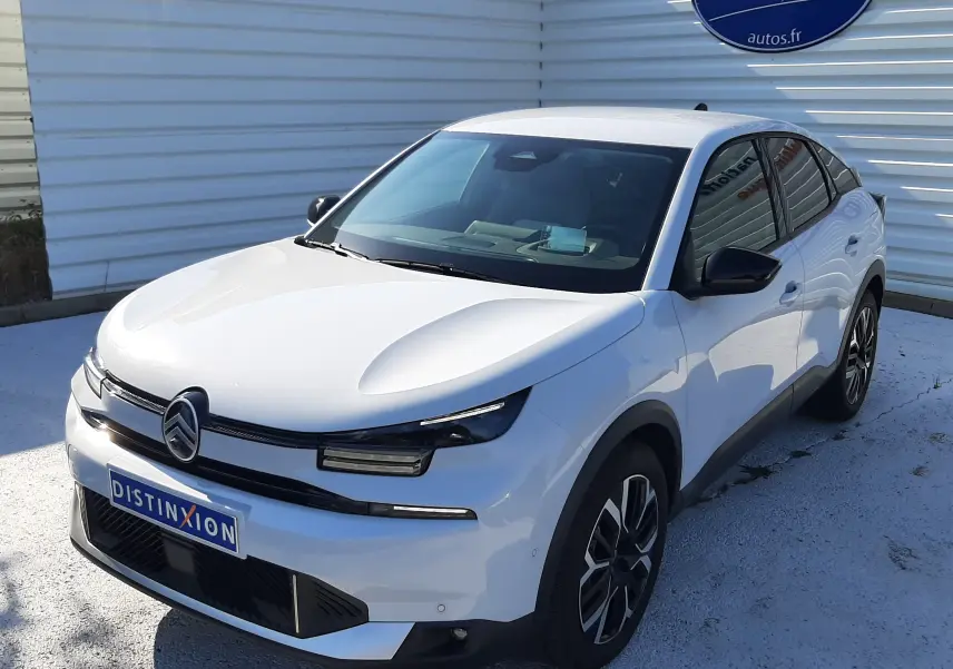 Vue 3/4 avant droite d'une Citroën C4 blanche Okenite 2025 avec jantes bi-ton et calandre moderne.