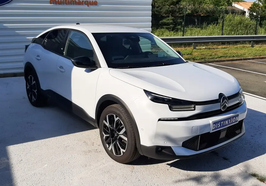 Citroën C4 blanc Okenite vue 3/4 avant droit, avec calandre distinctive et jantes bi-ton noires.