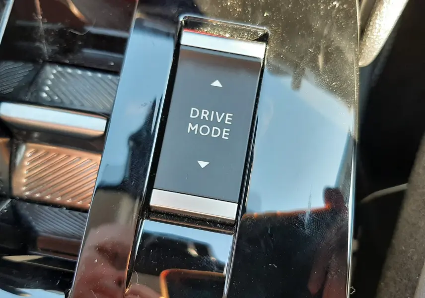 Gros plan sur le bouton Drive Mode dans la console centrale brillante du Citroën C4 hybride blanc Okenite 2025.