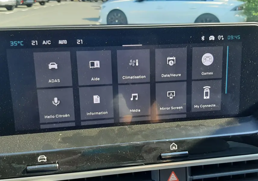 Vue intérieure centrée sur l’écran tactile du tableau de bord de la Citroën C4 blanche, affichant les options multimédia et climatisation.