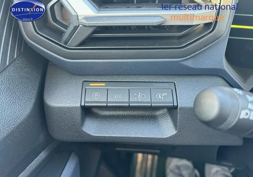 Boutons de commande sur tableau de bord du Dacia Duster gris schiste, vue rapprochée côté gauche sous l'aération.