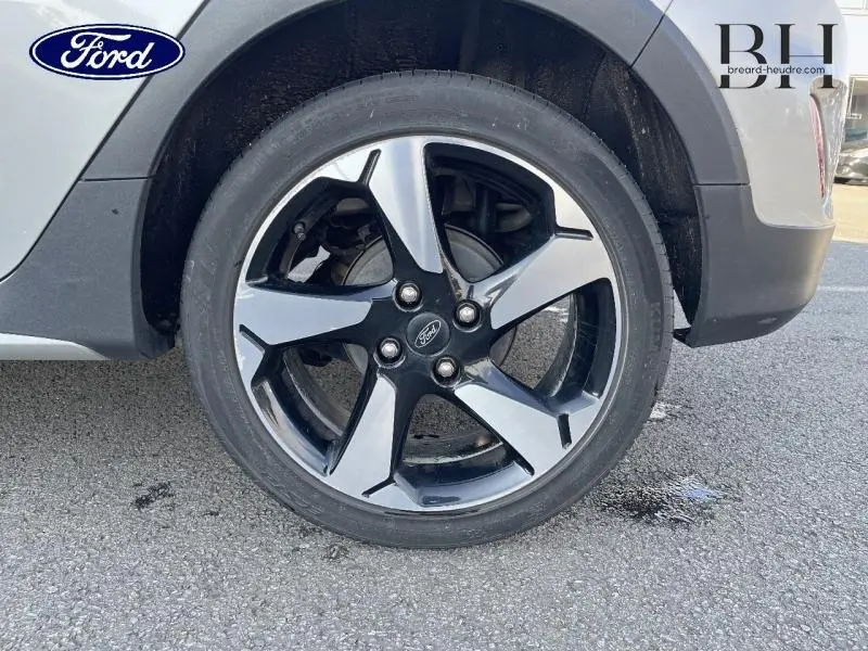 Gros plan sur la roue avant droite avec jante alliage bicolore noir et gris de la Ford Fiesta gris lunaire 2020.