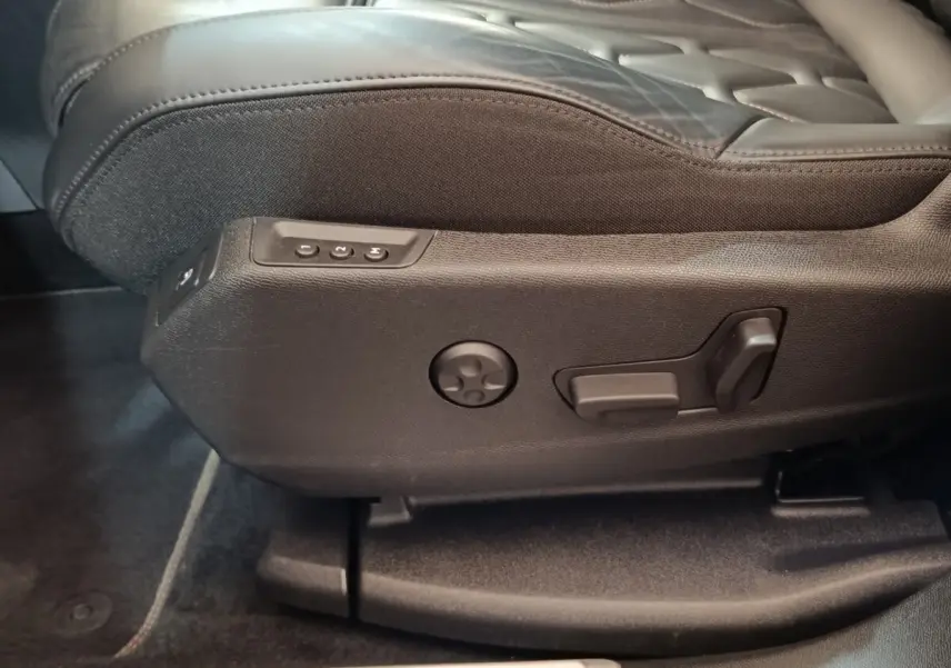 Détail des commandes de réglage électrique du siège avant noir du Peugeot 3008 hybride rechargeable bleu.