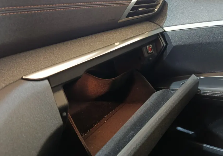 Intérieur du Peugeot 3008 GT Pack 2020, vue sur la boîte à gants ouverte avec finition tissu noir et surpiqûres marron.