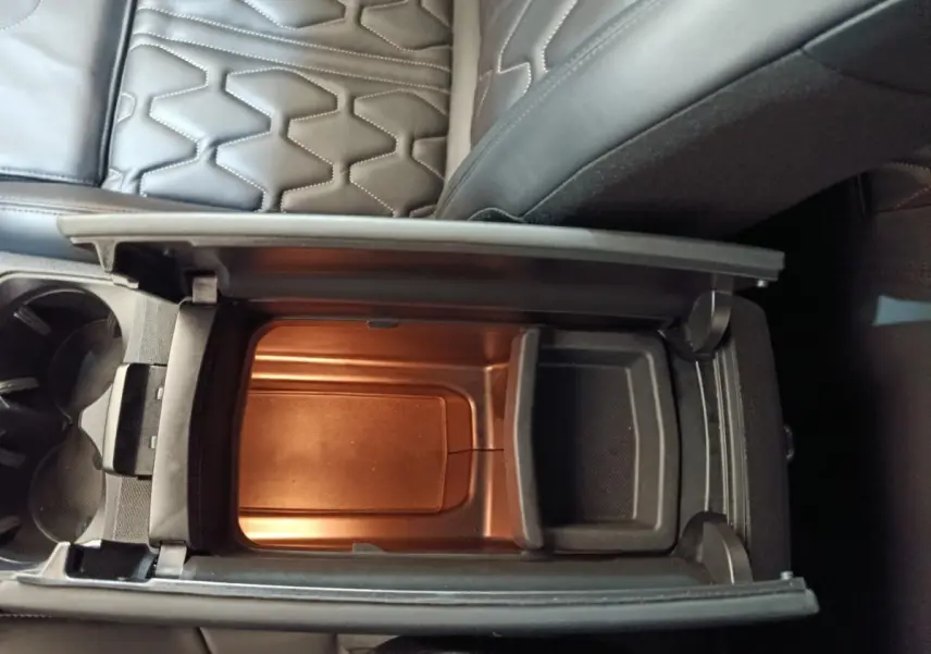 Vue plongeante sur le rangement réfrigéré noir entre les sièges en cuir noir du Peugeot 3008 hybride rechargeable.