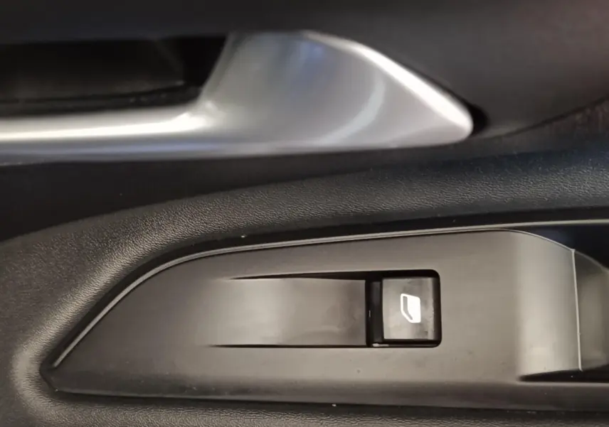 Détail du bouton de commande de lève-vitre côté gauche intérieur d’un Peugeot 3008 bleu hybride rechargeable.