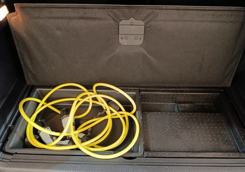 Coffre ouvert du Peugeot 3008 hybride rechargeable 2020, montrant le câble de recharge jaune rangé sous le plancher.