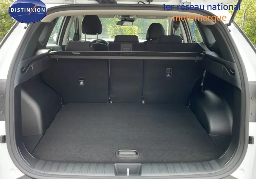 Coffre ouvert vu de l'arrière d'un Hyundai Tucson blanc Atlas 2026, montrant l'espace de chargement et la plage arrière.