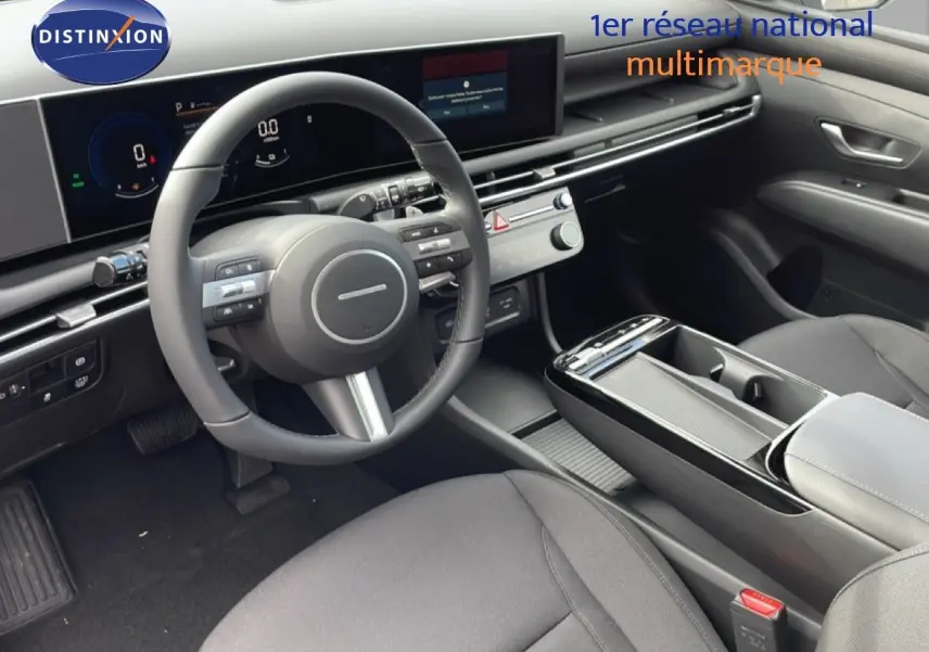 Vue intérieure côté conducteur du Hyundai Tucson 2026, tableau de bord numérique et volant multifonction en noir.