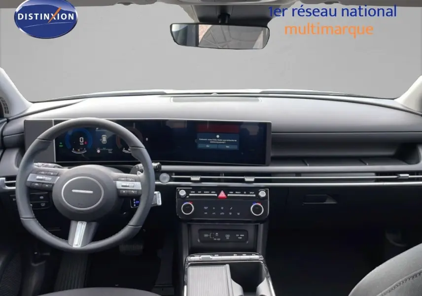 Vue intérieure frontale du tableau de bord noir du Hyundai Tucson 2026 avec écran large et volant multifonction.
