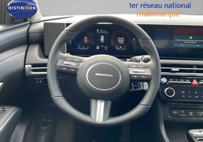Vue intérieure centrée sur le volant et le tableau de bord numérique du Hyundai Tucson blanc Atlas 2026.