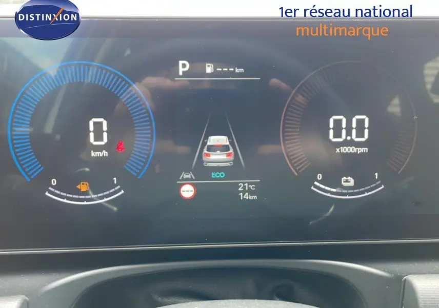 Tableau de bord numérique du Hyundai Tucson blanc, affichant la vitesse à 0 km/h et mode ECO en vue frontale.