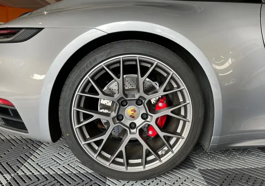 Gros plan sur la roue arrière droite argent GT d'une Porsche 911 Carrera S avec étrier de frein rouge et jante RS Spyder.