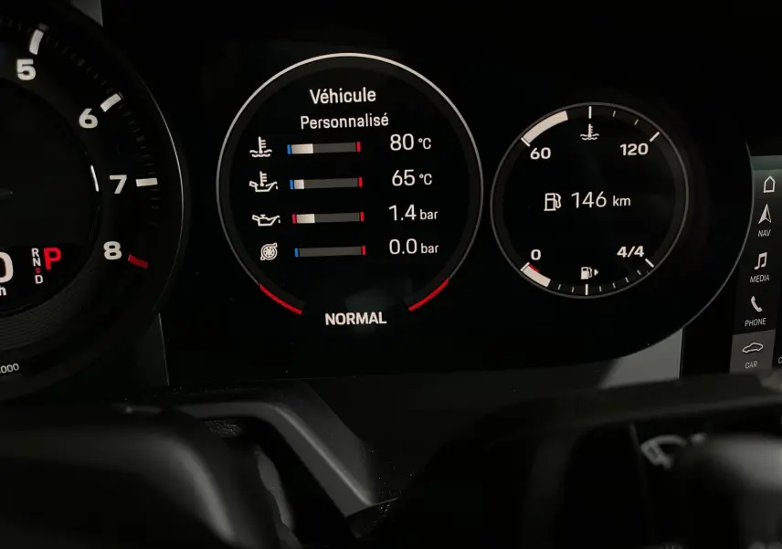Affichage numérique du tableau de bord de la Porsche 911 Carrera S 2019 montrant les températures et la distance restante.
