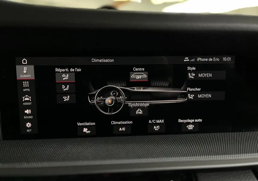 Écran tactile de climatisation affichant le tableau de bord et volant de la Porsche 911 Carrera S argent GT, intérieur noir.