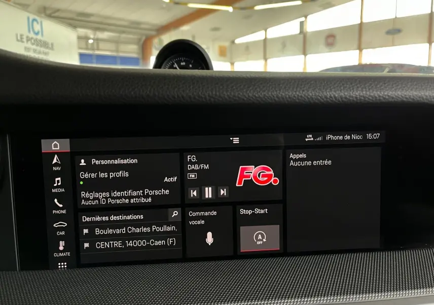 Écran central tactile de la Porsche 911 992 argent GT montrant les réglages et la radio FG en intérieur lumineux.