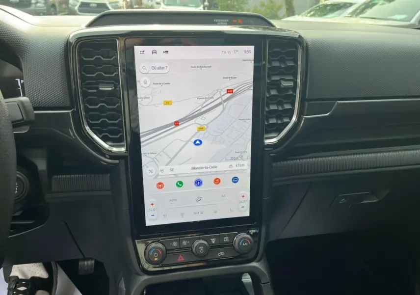 Vue centrale de l'écran tactile vertical du Ford Ranger 2025, affichant la navigation GPS et commandes climatisation.